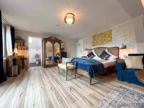 1 dormitorio con 1 cama y 1 sofá azul en Sieben Zimmer am See, en Prien am Chiemsee