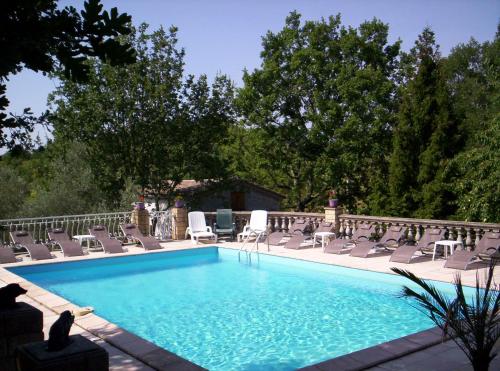 - une piscine avec des chaises longues et des chaises dans l'établissement Gite Les Cigales, à Labeaume