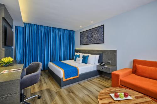 a hotel room with a bed and a couch at Zone By The Park Pathankot in Pathānkot