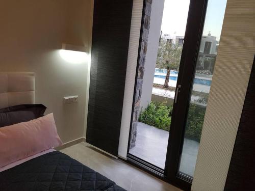 a bedroom with a sliding glass door to a balcony at EP Luxury Olea Valley Apartment in Nikiti