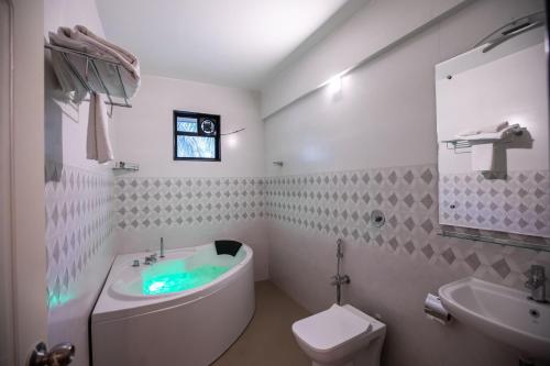 貝瑙利姆的住宿－The Woodside Inn，带浴缸、卫生间和盥洗盆的浴室