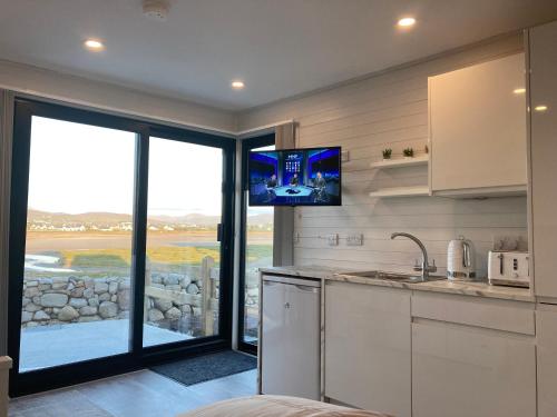a kitchen with a tv on the wall at Donegal Luxury Pods in Gweedore