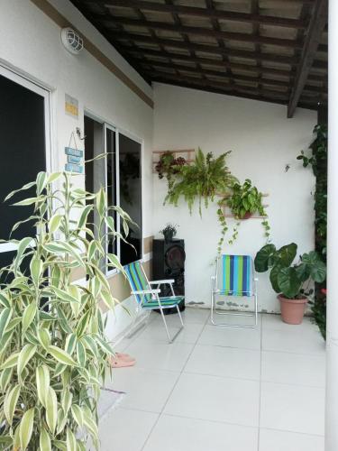 um pátio com cadeiras e plantas numa casa em Casa Aeroporto Maceió em Maceió