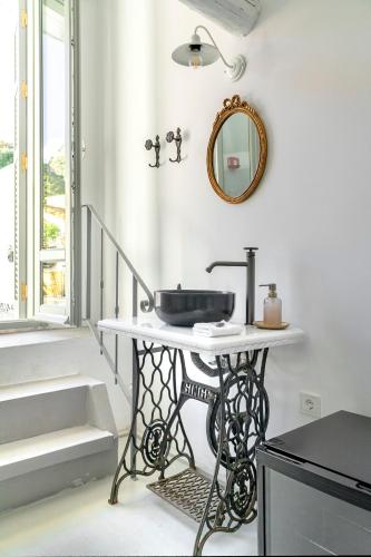 a bathroom with a sink and a mirror on the wall at Kastro Residence in Nafplio