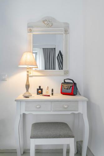 a white dressing table with a lamp and a mirror at Kastro Residence in Nafplio