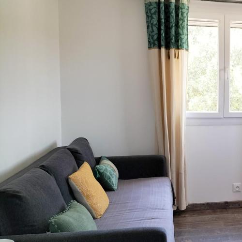 un canapé dans un salon avec une fenêtre dans l'établissement La Porte d'Orange, à Orange