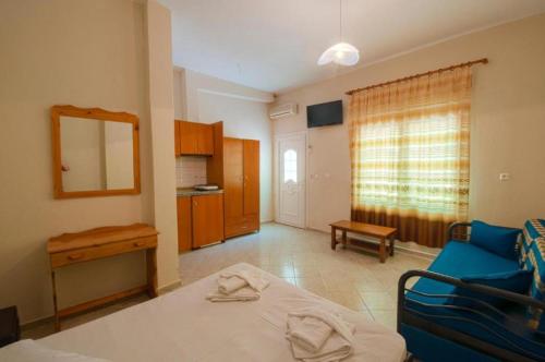 a living room with a bed and a blue couch at Sotiris Studios in Pefkari