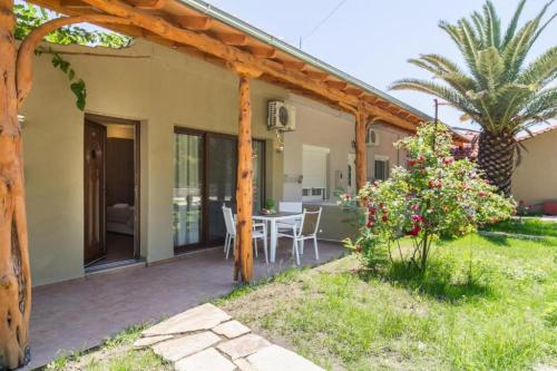 a patio of a house with a table and a palm tree at Sotiris Studios in Pefkari