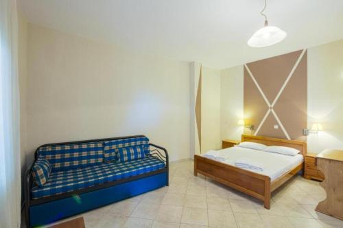 a bedroom with a bed and a couch at Sotiris Studios in Pefkari