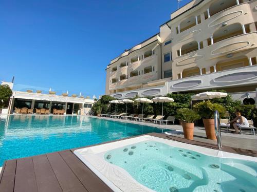 une piscine en face d'un hôtel dans l'établissement Hotel Derby Exclusive, à Milano Marittima