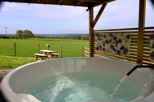 a bath tub filled with water in front of a field at West Wood Yurts Ltd in Newcastle upon Tyne