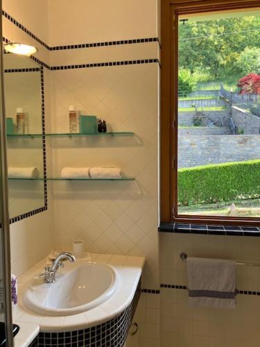 a bathroom with a sink and a window at relaxing green panorama in Margno