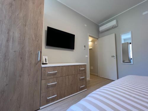 - une chambre avec un lit et une télévision murale dans l'établissement Turums B&B, à Castellammare del Golfo