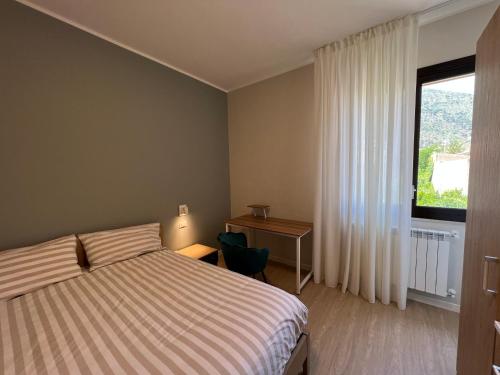 une chambre avec un lit, un bureau et une fenêtre dans l'établissement Turums B&B, à Castellammare del Golfo