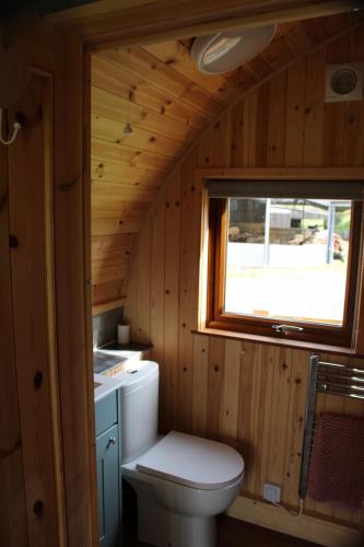 a small bathroom with a toilet and a window at West Wood Yurts Ltd in Newcastle upon Tyne