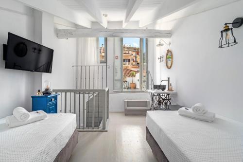 a white room with two beds and a tv at Kastro Residence in Nafplio