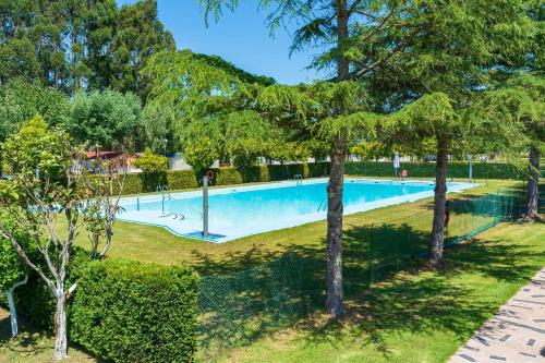 an empty swimming pool in a park with trees at Kampaoh Río Miño in A Guarda