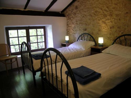 1 dormitorio con 2 camas, 2 sillas y ventana en Totally Secluded Stone Cottage with Private Pool, 2 acres of Garden and Woodland, en Paussac-et-Saint-Vivien