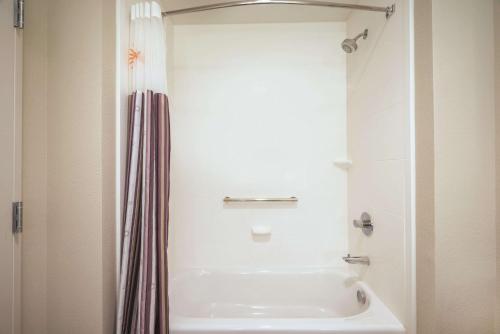 a white bathroom with a tub and a shower at La Quinta by Wyndham Memphis Downtown in Memphis