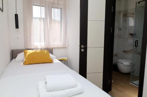una camera con letto e cuscino giallo di Lučica, Luxury Rooms By the Sea a Pučišća