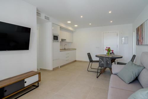 內爾哈的住宿－Solymar Sun & Beach Deluxe Apartments，客厅配有沙发和桌子