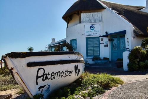 an old boat sitting in front of a house at Gilcrest Place Guest House in Paternoster