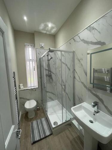 a bathroom with a shower and a sink and a toilet at Luxury 2 Bedroom Cottage in West Calder