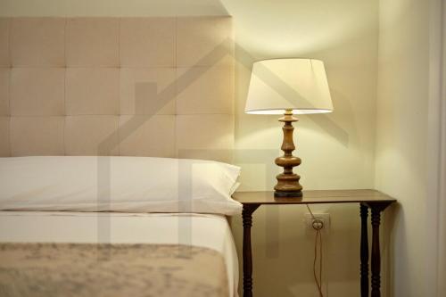 a lamp sitting on a table next to a bed at Casona del Sol El Retorno I in Lastres