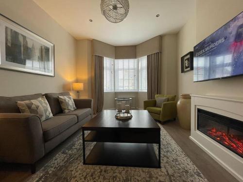 un soggiorno con divano e camino di Luxury 2 Bedroom Cottage a West Calder