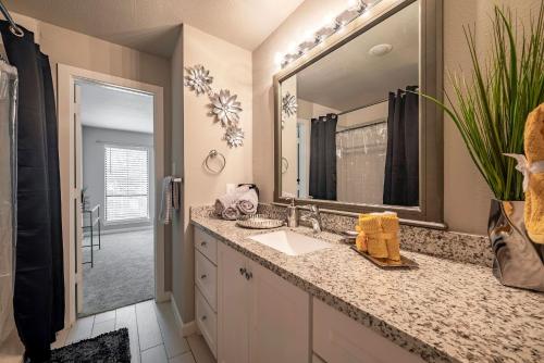 a bathroom with a sink and a mirror at 2 Galleria Downtown 3BR Free Parking Summer Time in Houston