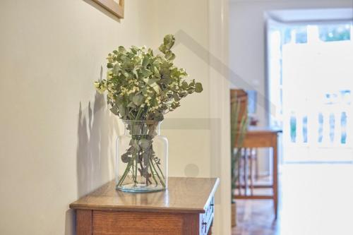 a glass vase filled with flowers on a table at Casona del Sol El Retorno I in Lastres