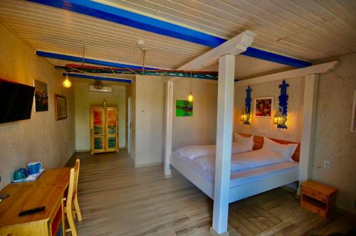 1 dormitorio con cama, mesa y escritorio en Nena Art Resort, en Dunavăţu de Jos