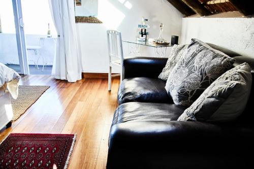 a black leather couch sitting in a living room at Gilcrest Place Guest House in Paternoster