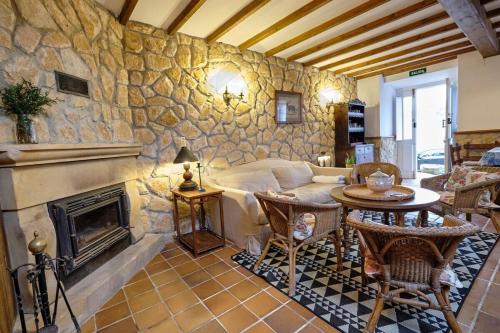 a living room with a stone wall with a fireplace at Casona del Sol El Retorno I in Lastres