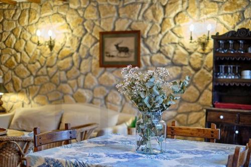 a table with a vase of flowers on it at Casona del Sol El Retorno I in Lastres
