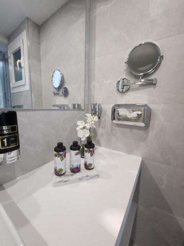 Un baño con un mostrador blanco con flores. en Diamante Paguera Boutique Hotel, en Paguera