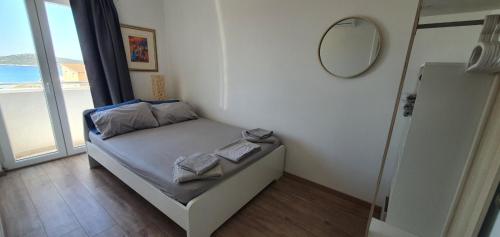 um pequeno quarto com uma cama e um espelho em Apartments Rita em Dolac