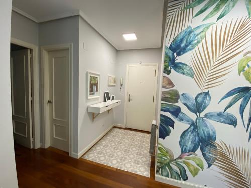 a bathroom with a mural of plants on the wall at Apartamento Playa Ostende ,Garaje incluido in Castro-Urdiales