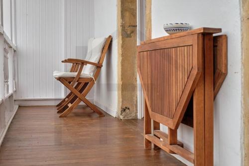 a wooden chair sitting next to a table at Casona del Sol El Retorno I in Lastres