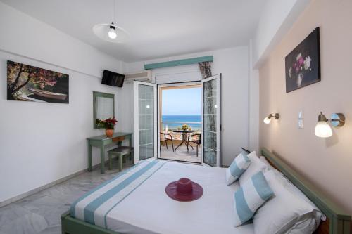 a bedroom with a bed with a view of the ocean at Sunrise Apartments in Sfakaki
