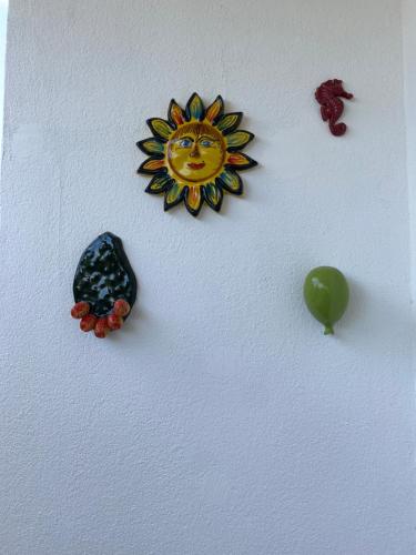 a wall with a sun and other objects on it at Dimore Capirro Charming Family House in Trani