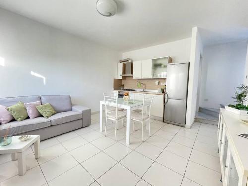 un salon avec un canapé et une table et une cuisine dans l'établissement appartamento la torre, à Pietrasanta