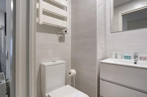 biała łazienka z toaletą i umywalką w obiekcie 1 bedroom 1 bathroom furnished - Av de America - studio - MintyStay w Madrycie