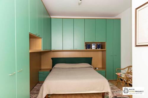 Madonna del SassoにあるCasa Liviya - Appartamento con vista lagoの緑のキャビネットとベッド付きのベッドルーム1室