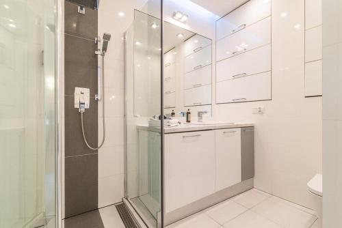 a white bathroom with a shower and a sink at Chłodna 15 by Homeprime in Warsaw