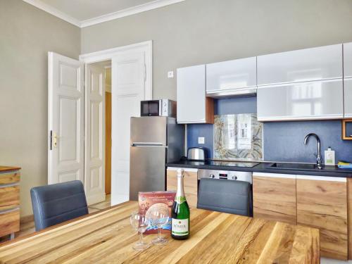eine Küche mit einem Holztisch mit Weingläsern darauf in der Unterkunft Carlsbad Family Apartment in Karlsbad