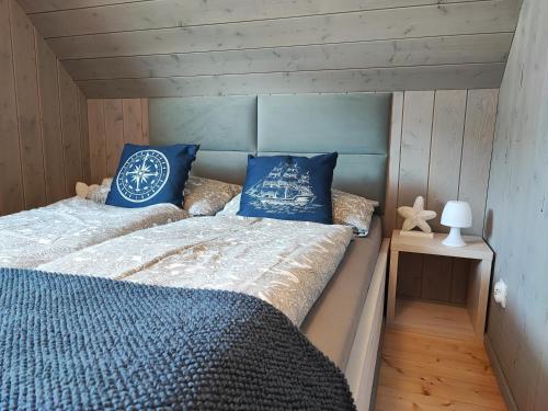 ein Schlafzimmer mit zwei Betten mit blauen Kissen in der Unterkunft Słoneczny Raj Apartamenty Domki apartamentowe in Sarbinowo