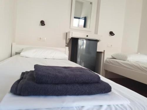 a blue towel sitting on top of a bed at Zinas pension in Ios Chora