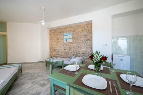 a dining room with a table and chairs and a brick wall at Sunrise Apartments in Sfakaki