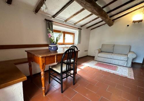 a room with a table and a chair and a couch at L'Aiolina in Vagliagli